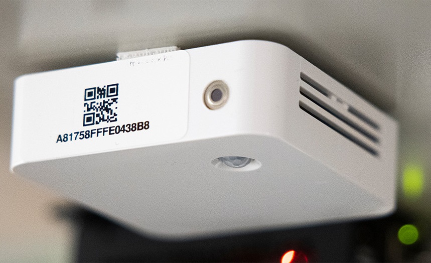 An indoor air quality monitoring device mounted under a table.